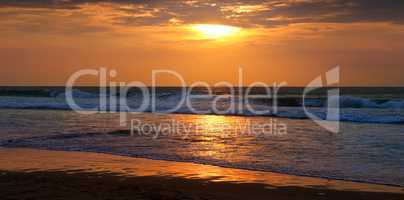 Beach of the ocean and golden sun rise. Wide photo.