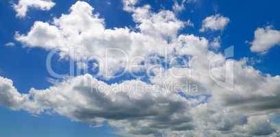 Cumulus clouds in the blue sky. Wide photo.