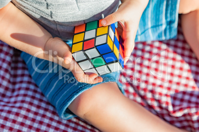 Baby Boy Sitting on Picnic Blanket Playing With Cube Puzzle