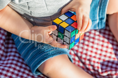 Baby Boy Sitting on Picnic Blanket Playing With Cube Puzzle