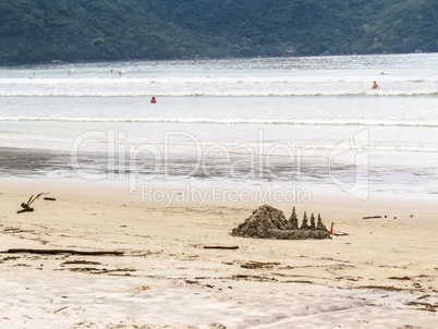 Sand castle landscape on beach with waves.
