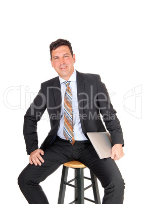 Happy businessman sitting with his laptop