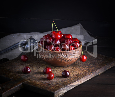 ripe red cherry in a round clay bowl