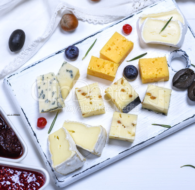 pieces of brie cheese, roquefort, camembert, cheddar and cheese