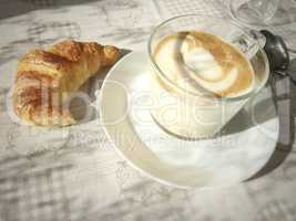 foamy Cappuccino mug and a croissant