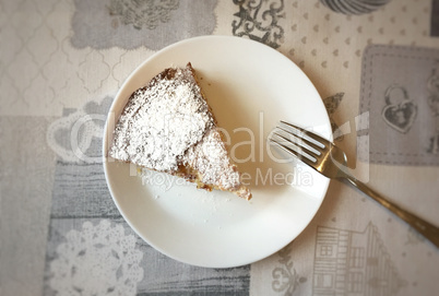 Aerial view of a white plate with a slice of cake
