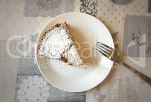 Aerial view of a white plate with a slice of cake