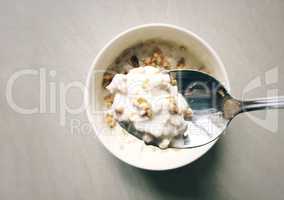 Top view of a spoon filled with yogurt and cereal