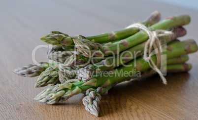 Close-up of fresh green asparagus wrapped with rope. angle view