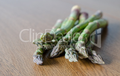 Close-up of fresh green asparagus on wooden background. angle vi