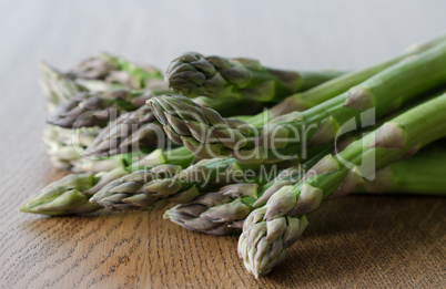 Close-up of fresh green asparagus on wooden background. angle vi