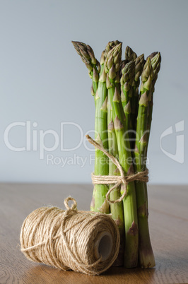 Close-up of fresh green asparagus wrapped with rope. side view