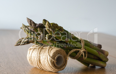 Close-up of fresh green asparagus wrapped with rope. side view