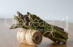 Close-up of fresh green asparagus wrapped with rope. side view