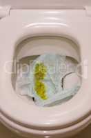 Closeup of yellow dirty stinky diaper of new born baby in the toilet bowl