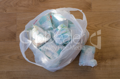 a bag full of dirty baby's diapers standing on the floor high