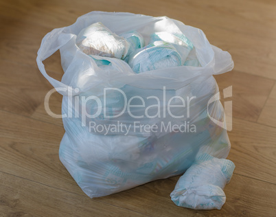 a bag full of dirty baby's diapers standing on the floor angle