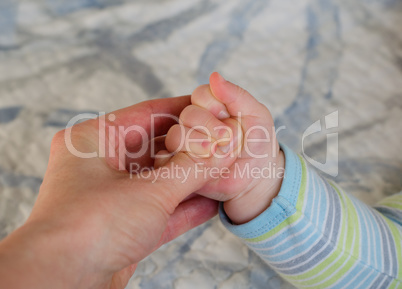 Close-up of mom hand holding baby hand