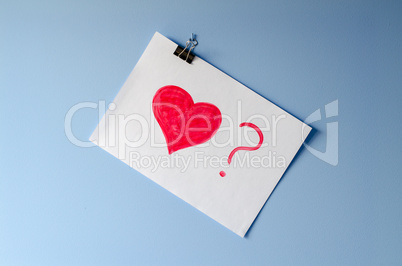 The painted red heart with ? on white paper sheet