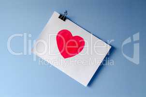 The painted red heart on white paper sheet love background