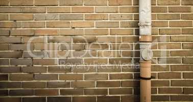 brown brick wall with drainpipe on the right side of frame backg