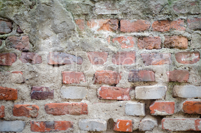 old grey concrete garage wall with red bricks and cracks abstrac