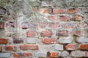 old grey concrete garage wall with red bricks and cracks abstrac