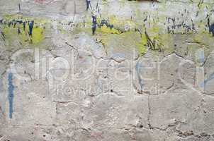 gray concrete garage wall with spots of black and green paint ab