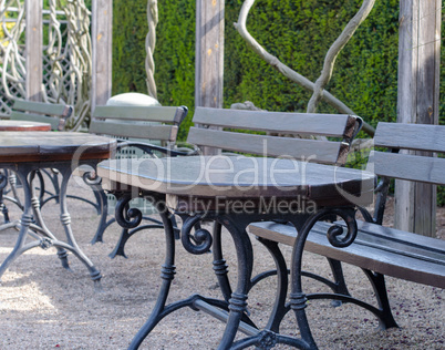 a set of empty benches and tables outside