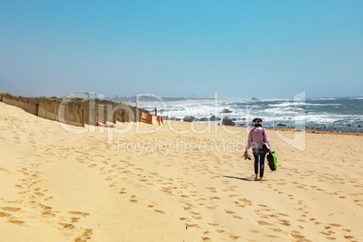 Woman is walking on the sandy beach