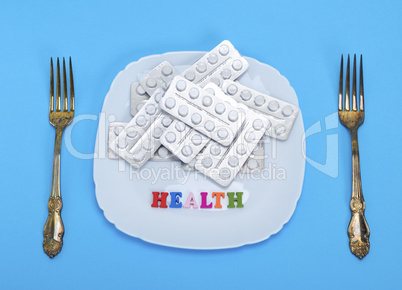 white tablets in a package on a square ceramic plate