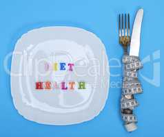 square plate and fork with knife wrapped in a measuring tape