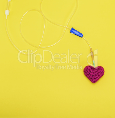 plastic catheter with needle and red heart