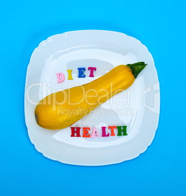 yellow raw squash lies in a white square ceramic plate