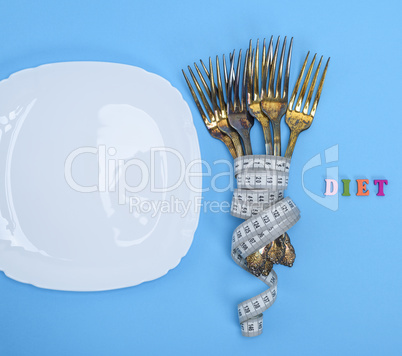 empty white square plate and forks wrapped in a measuring tape