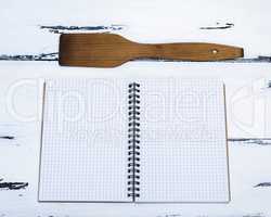 open empty notebook in a box and a kitchen spatula