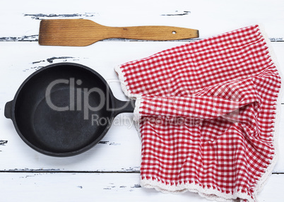 empty black round cast-iron frying pan and red napkin