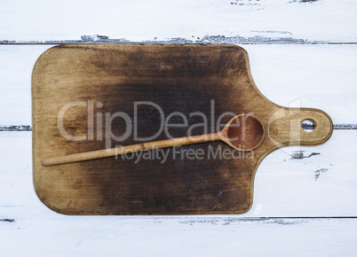 brown old kitchen cutting board and wooden spoon