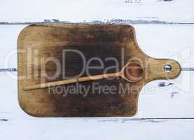 brown old kitchen cutting board and wooden spoon
