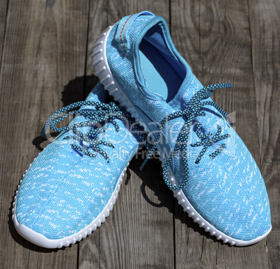 textile blue shoes on a gray wooden surface