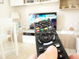 Male hand holding TV remote control
