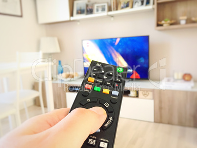 Male hand holding TV remote control