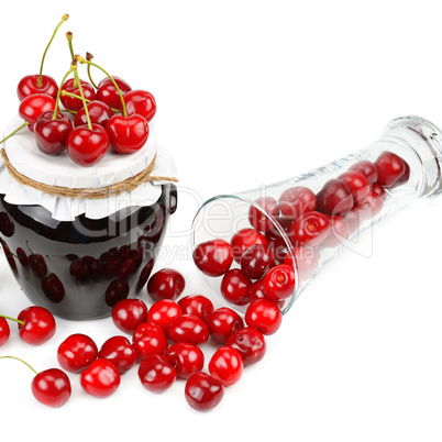 Cherries and jars of jam isolated on a white.