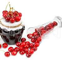 Cherries and jars of jam isolated on a white.