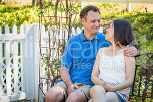 Young Caucasian Man and Chinese Woman Sitting On Bench