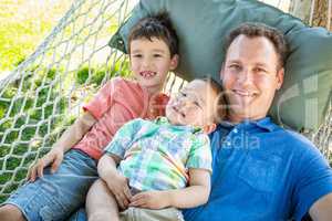 Caucasian Father Relaxing In Hammock with Mixed Race Chinese Son
