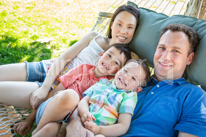 Caucasian Father and Chinese Mother Relaxing In Hammock with Mix