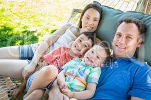 Caucasian Father and Chinese Mother Relaxing In Hammock with Mix