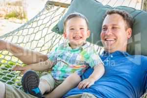 Caucasian Father Relaxing In Hammock with Mixed Race Chinese Son