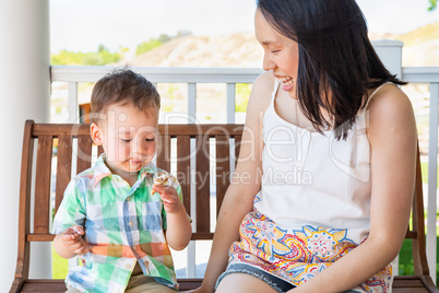 Young Chinese Mother Sitting With Her Mixed Race Chinese and Cau